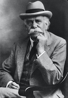A photo of Dr Hadwen, seated, wearing a suit and hat, and sporting a large moustache